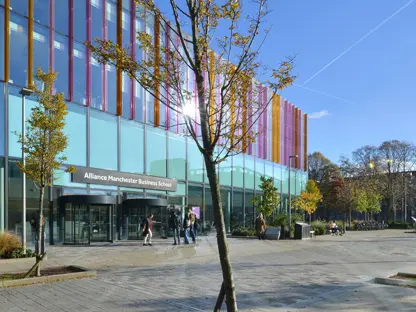 Alliance Manchester Business School building with a tree in front of it in the sunlight