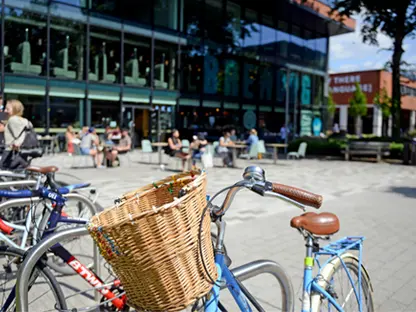 A bike rack with bikes in front of the shops on University Green