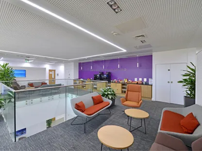 A communal area in the Executive Education centre, with chairs and round tables and a refreshment area