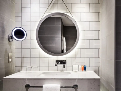 A bathroom in the Hyatt Hotel with circle mirror and marble sink