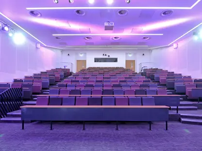 A lecture theatre in AMBS lit up with purple lighting