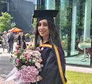 A photograph of Lida Koutso outside Alliance Manchester Business School on her graduation day