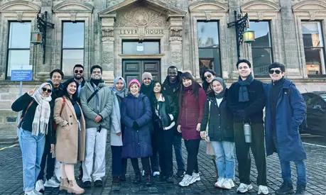 Full-time MBA students stood together in a carpark in Port Sunlight Village