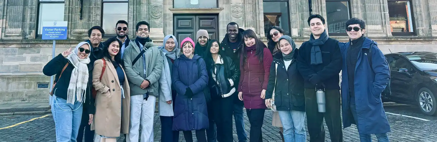 Full-time MBA students stood together in a carpark in Port Sunlight Village