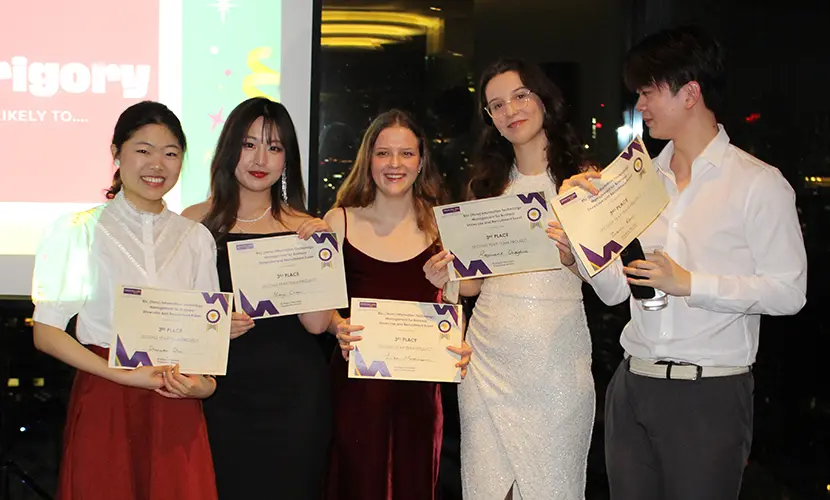 A group of five students posing for a photo with award certificates.