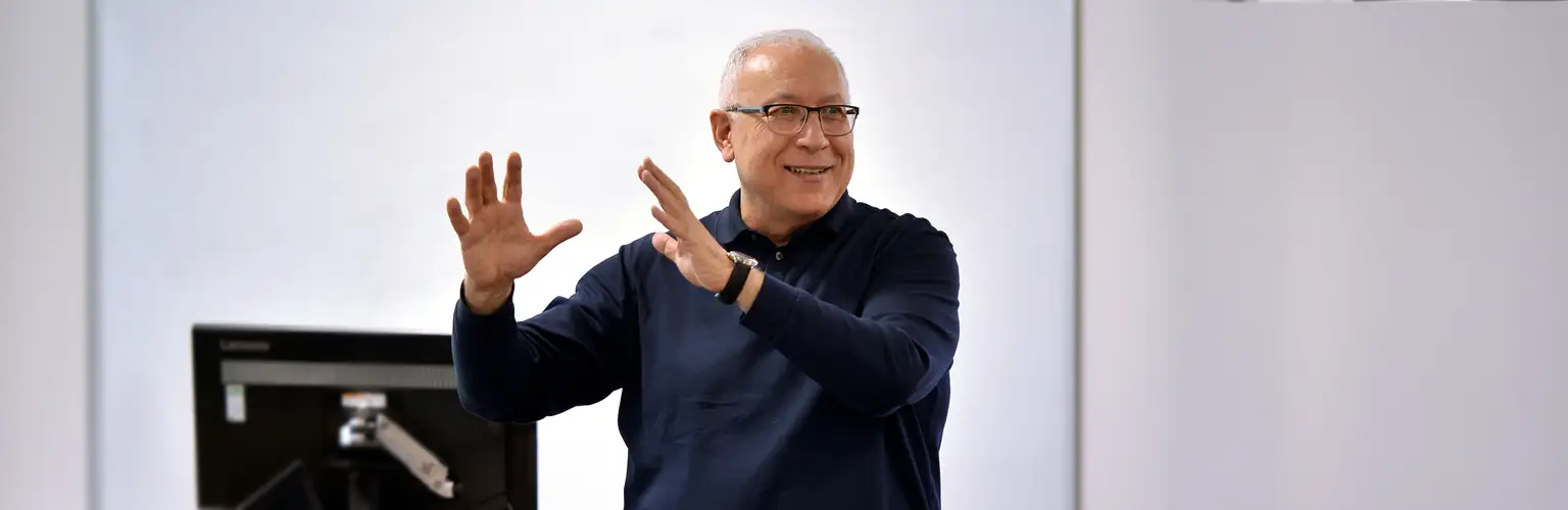 Ismail Erturk teaching at the front of a classroom