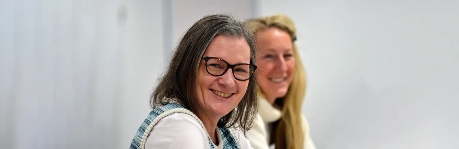 Two women smiling in classroom