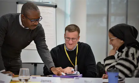 Three professionals having a conversion in a classroom