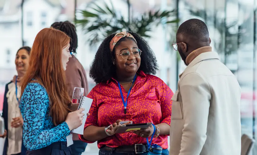 A group of mixed age professionals networking at a conference