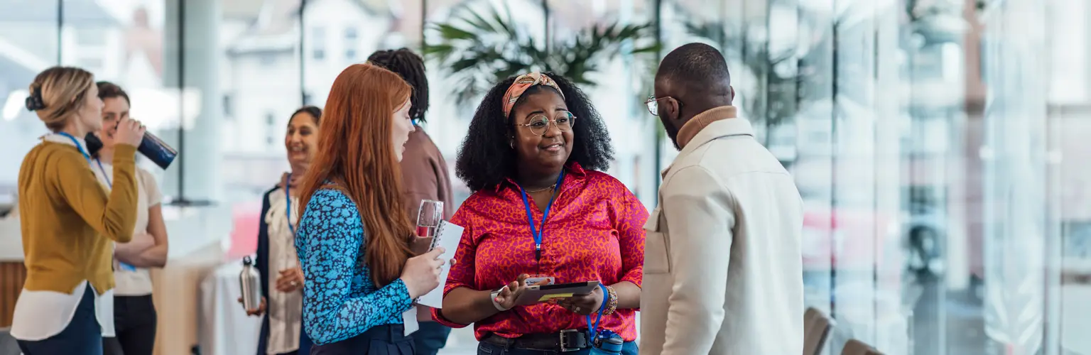 A group of mixed age professionals networking at a conference