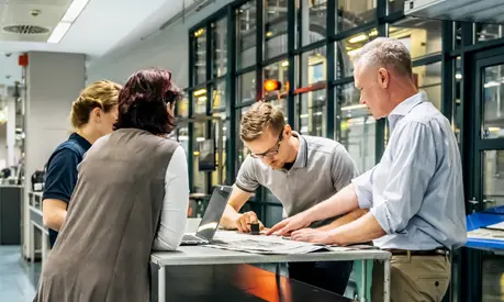 Business meeting of staff and management close to a production line