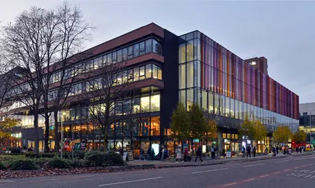 Alliance Manchester Business School building with a tree in front of it in the evening light