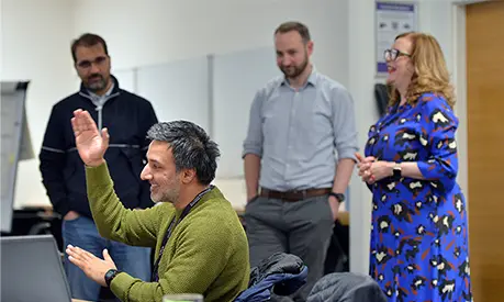 A group of professionals in a classroom environment listening to someone give a presentation