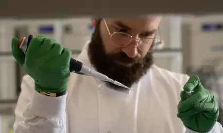 Mohammad El Hajj, CEO of Bright Biotech in a laboratory holding a needle and test tube