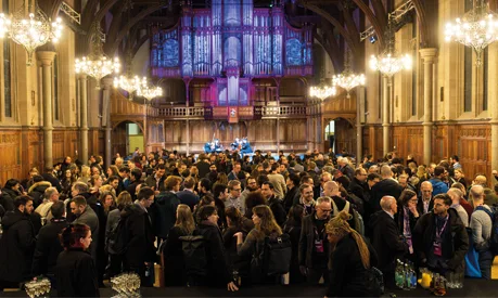 A crowd of people at a conference in a big church hall