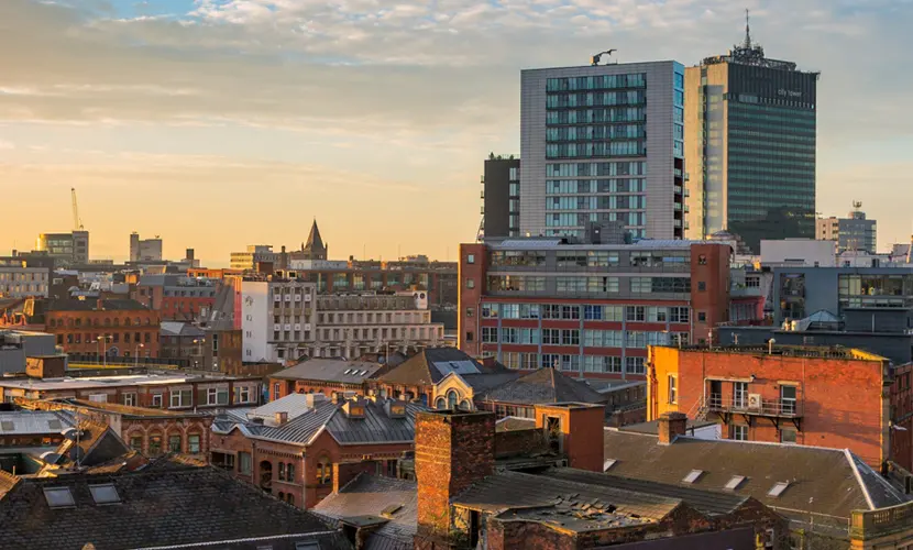 A view of the Manchester City centre skyline at sunset