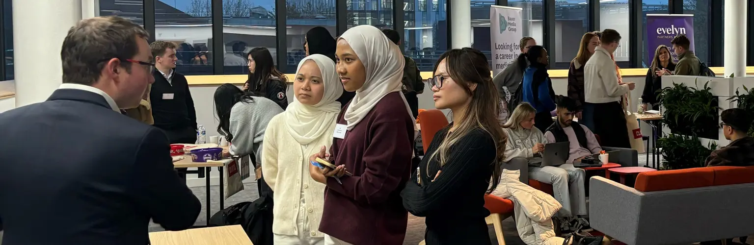 Three accounting students talking with an industry professional