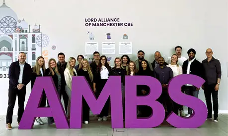 Delegates of the Chiesi customised programme posing together with big 'AMBS' letters in front of them