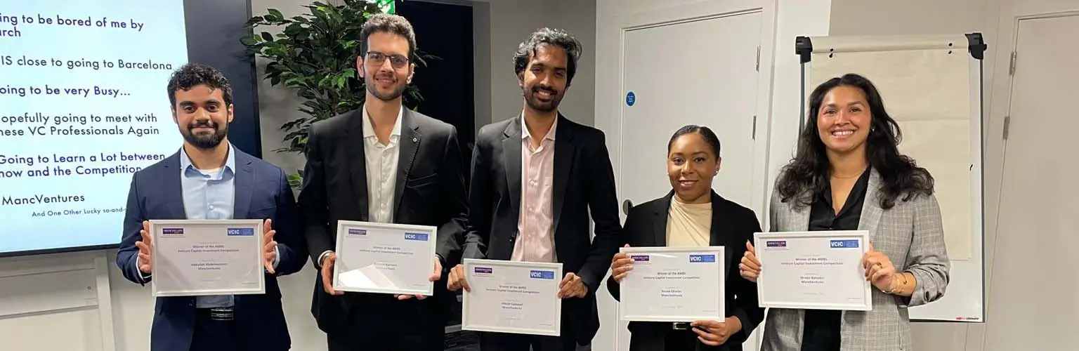 A group of five MBA students holding up certificates