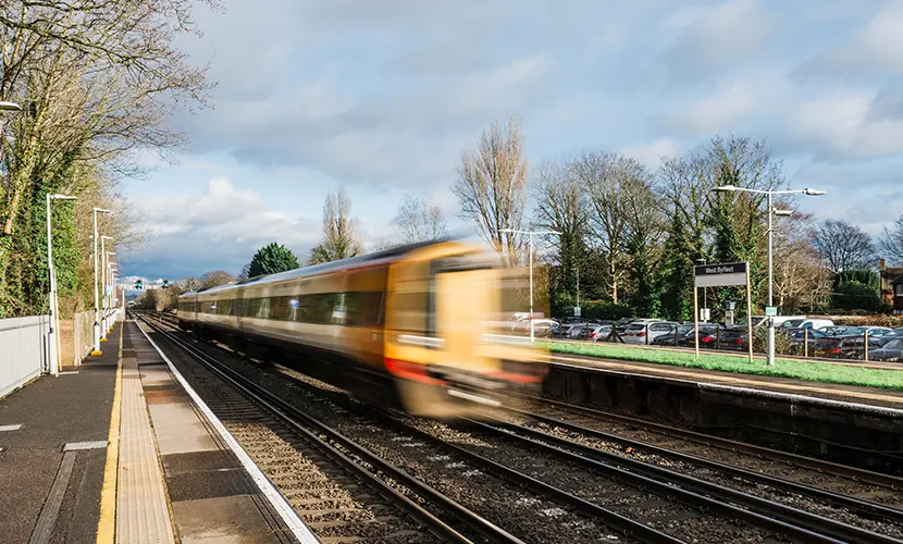 A train speeding through an empty station in Surrey.