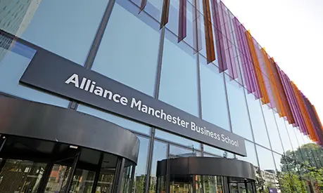 Alliance Manchester Business School entrance with purple and orange glass panels.