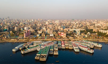 An aerial view of the Sadarghat Launch Terminal within the Dhaka city skyline.