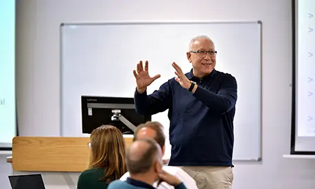 Ismail Erturk teaching at the front of a classroom of senior leaders