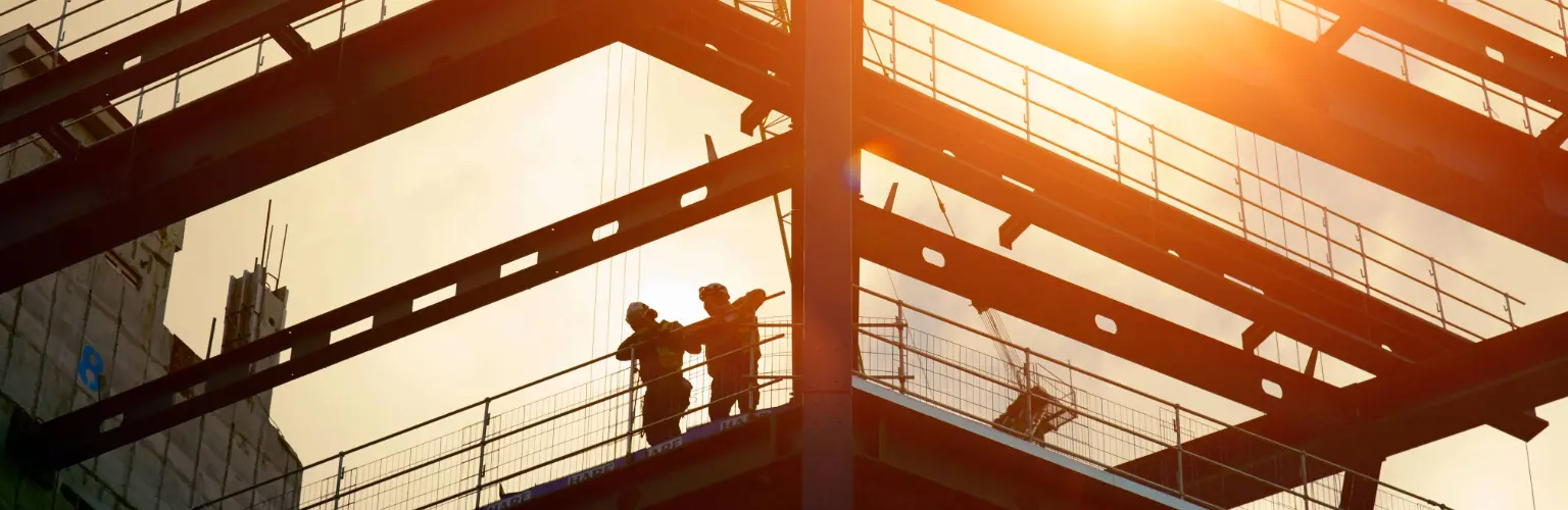 Construction workers silhouetted against the sun