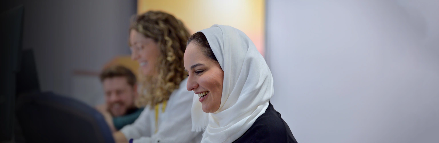 A group of professionals smiling and collaborating in a work environment