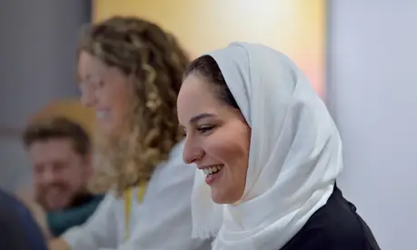 A group of professionals smiling and collaborating in a work environment