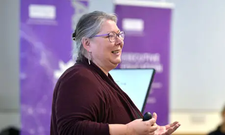 Dr Dawn Holmes teaching at the front of a classroom