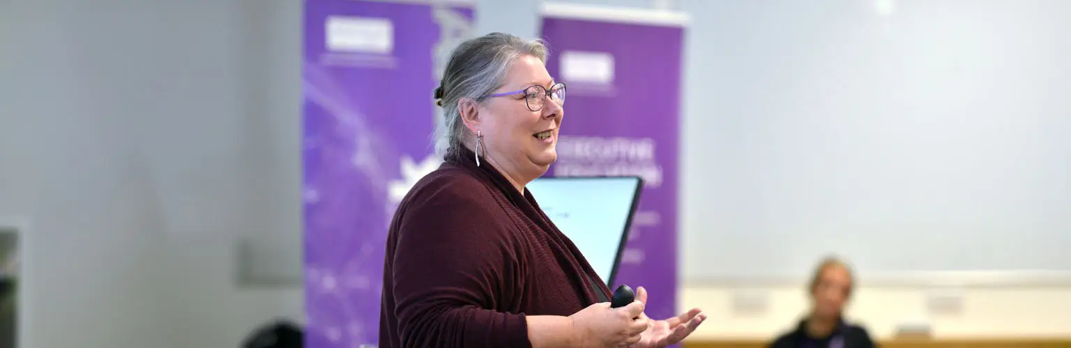 Dr Dawn Holmes teaching at the front of a classroom