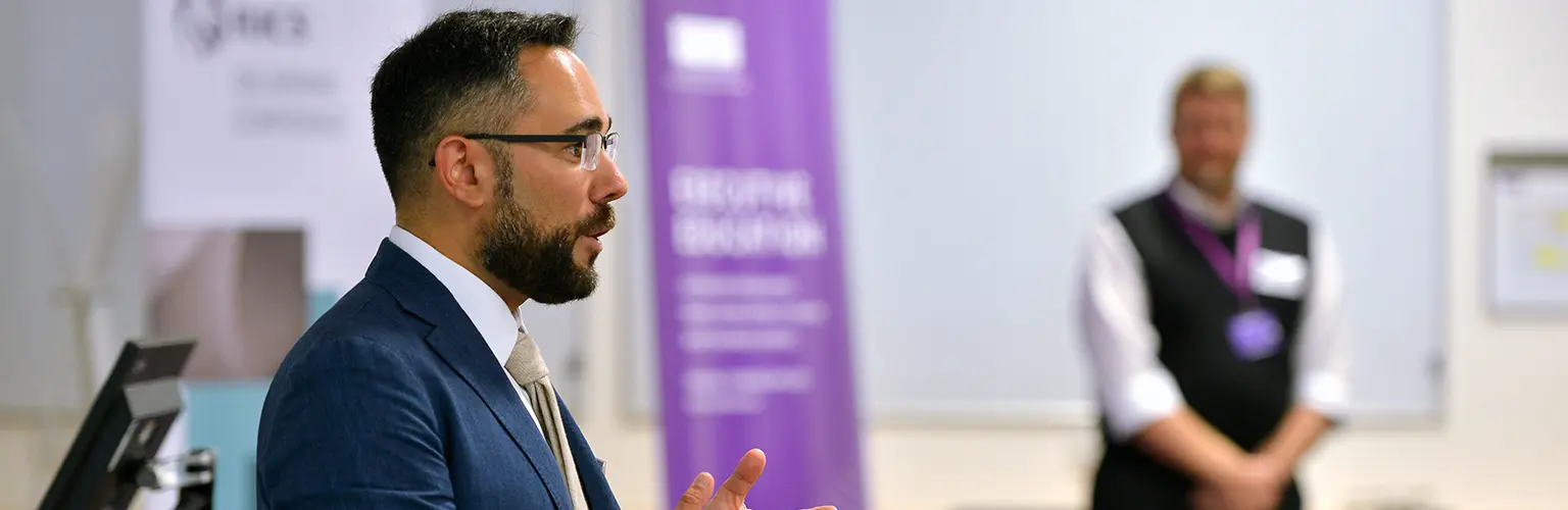 An academic professor teaching at the front of a classroom