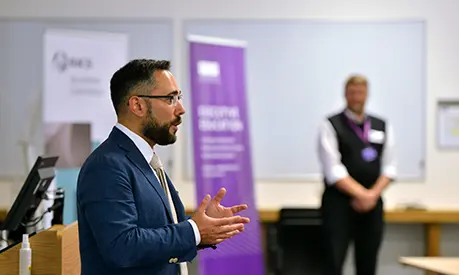 An academic professor teaching at the front of a classroom