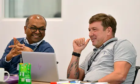 Two business professionals sat around a table discussing project work
