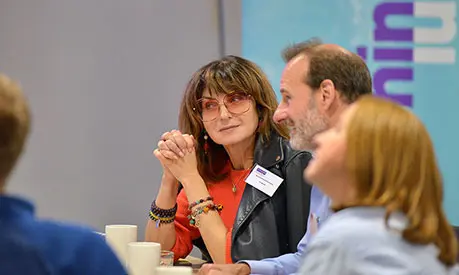 A group of senior professionals sitting together in a classroom environment